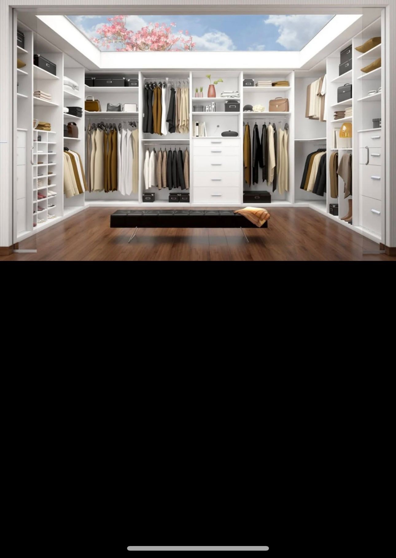 Modern walk-in closet with white shelves, hanging clothes, and a bench under a skylight.